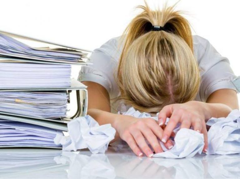 lo stress correlato al lavoro, immagine con impiegata stressata per il lavoro